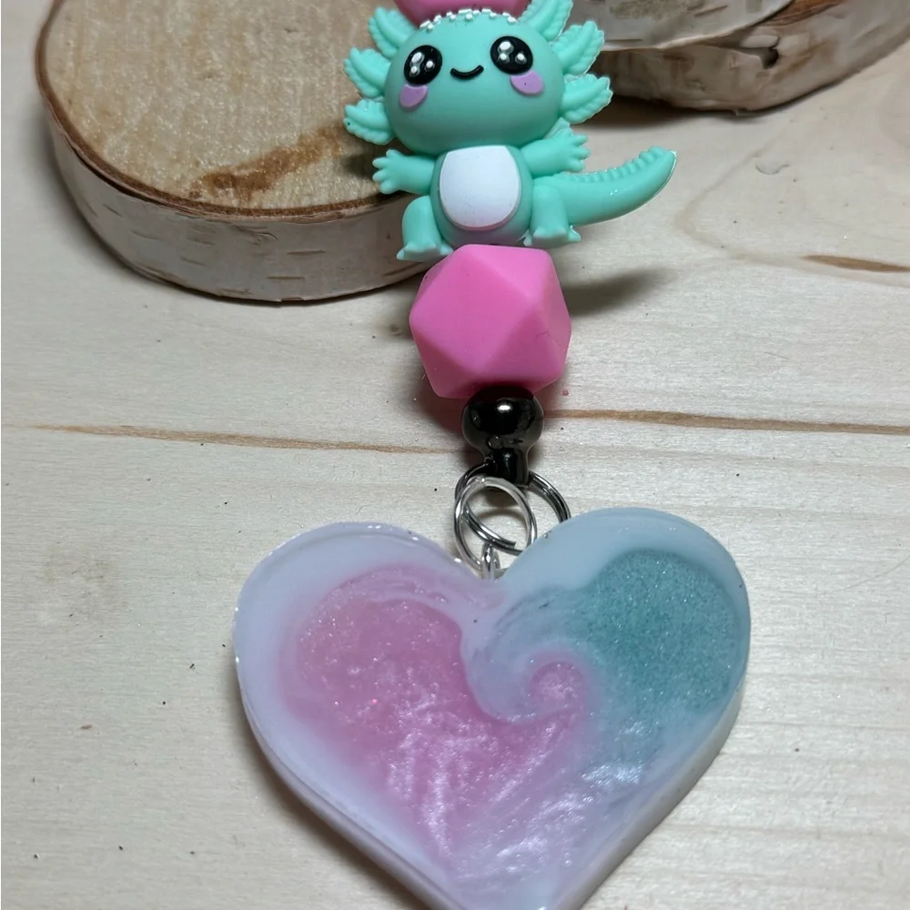 axolotl keychain with a pink and teal or blue resin heart pendant